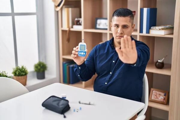 Hispánec Mladý Muž Drží Glukometr Zařízení Otevřenou Rukou Dělat Stop — Stock fotografie