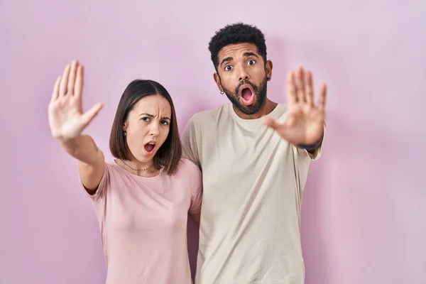 Young Hispanic Couple Together Pink Background Doing Stop Gesture Hands — 图库照片