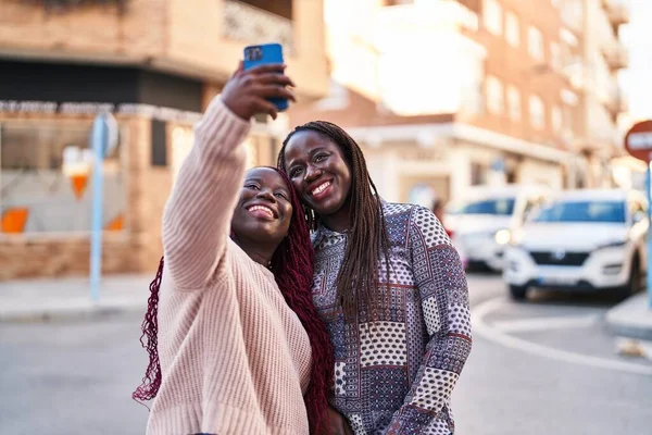 自信を持って笑顔でアフリカ系アメリカ人女性の友人作る自画自画自賛通りでスマートフォン — ストック写真