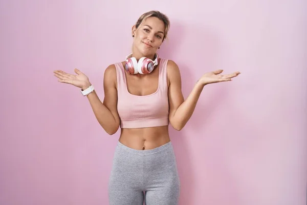 Young Blonde Woman Wearing Sportswear Headphones Clueless Confused Expression Arms — Stock Photo, Image