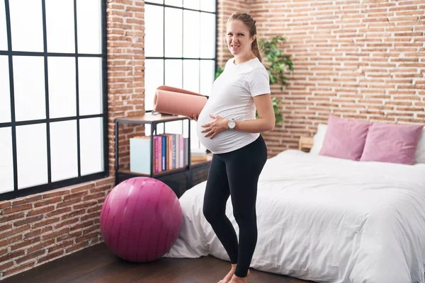 Mujer Embarazada Joven Sosteniendo Alfombra Pilate Dormitorio Expresión Despistada Confusa —  Fotos de Stock