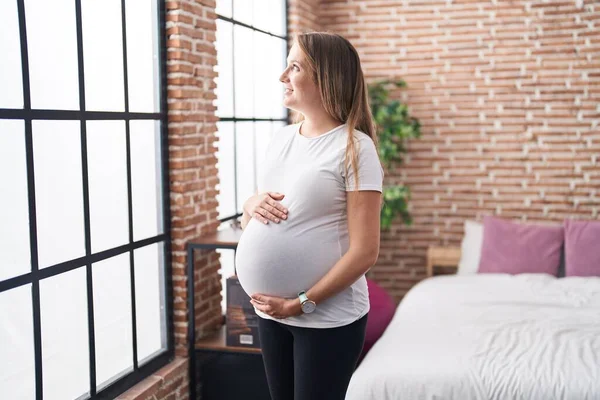 Mladá Těhotná Žena Usměvavá Sebevědomě Dojemné Břicho Stojící Ložnici — Stock fotografie