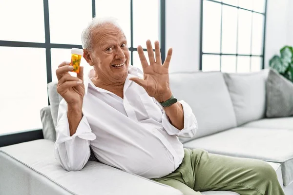 老人拿着药丸放弃打招呼快乐微笑友好的欢迎手势 — 图库照片