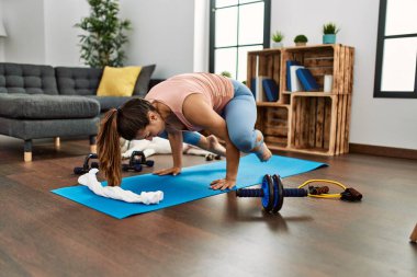 Young woman training yoga at home