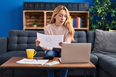 Evdeki kanepede oturan genç kadın.