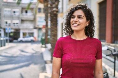 Sokakta kendine güvenen genç Latin kadın gülümsüyor