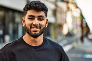 Sokakta kendinden emin gülümseyen genç bir Arap.