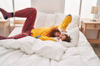 Young redhead man covering ears for noise at bedroom