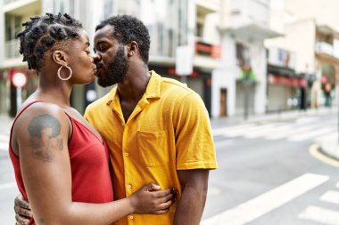 Genç Afro-Amerikan çift şehirde sarılıp öpüşüyorlar..