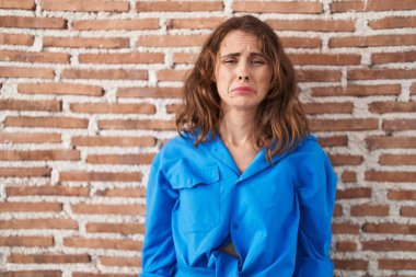 Güzel esmer kadın duvarın başında duruyor. Depresyonda ve üzüntüden ağlıyor. Kızgın ve korkmuş. hüzünlü ifade. 