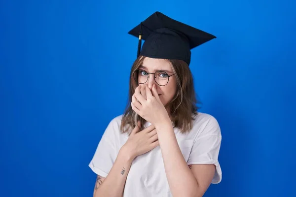 金发女人戴着毕业典礼帽 闻到一股难闻难闻难闻的气味 用手指捂住鼻子屏住呼吸 — 图库照片