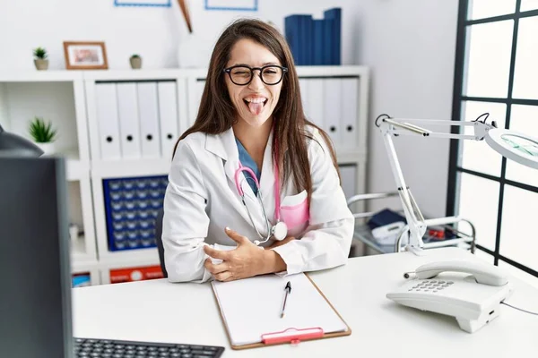 Mujer Doctora Joven Vistiendo Uniforme Médico Estetoscopio Clínica Sacando Lengua —  Fotos de Stock