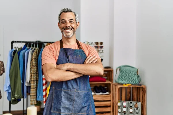 stock image Middle age grey-haired man shop assistant standing with arms crossed gesture at clothing store