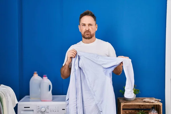 Hombre Caucásico Mediana Edad Sosteniendo Camisa Con Sudor Escéptico Nervioso —  Fotos de Stock
