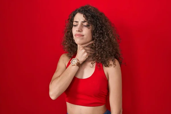 Hispanic Woman Curly Hair Standing Red Background Touching Painful Neck — ストック写真