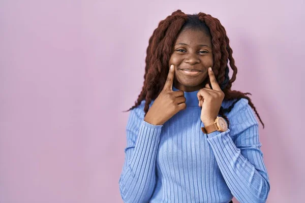 Африканская Женщина Стоит Розовом Фоне Улыбаясь Открытым Ртом Пальцы Указывая — стоковое фото