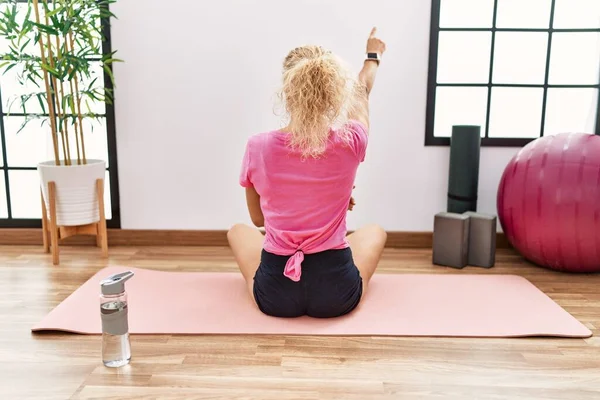 Middle Age Blonde Woman Sitting Yoga Mat Posing Backwards Pointing — Stock Photo, Image