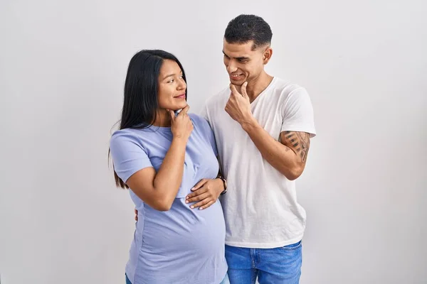 Young Hispanic Couple Expecting Baby Standing Background Looking Confident Camera — Stock Photo, Image