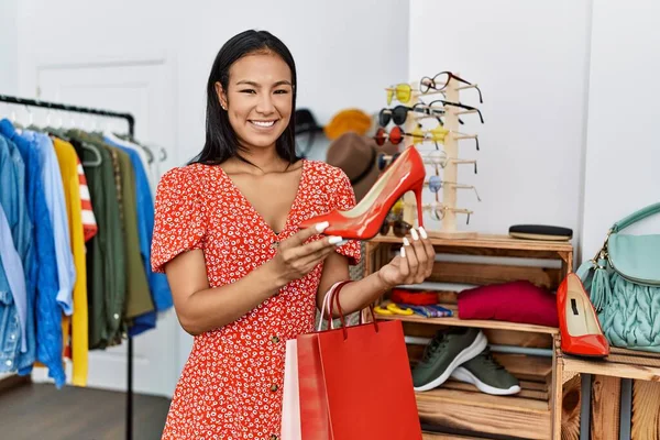 stock image Young latin woman smiling confident holding high heel shoe at clothing store