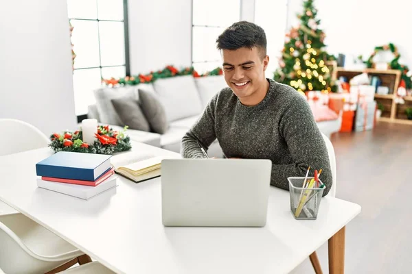 Νεαρός Ισπανόφωνος Σπουδάζει Χρησιμοποιώντας Φορητό Υπολογιστή Καθισμένος Στο Χριστουγεννιάτικο Δέντρο — Φωτογραφία Αρχείου