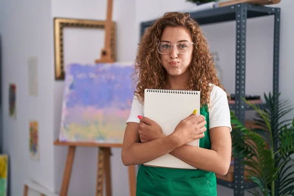 Joven Mujer Caucásica Sosteniendo Cuaderno Arte Soplando Mejillas Con Cara —  Fotos de Stock