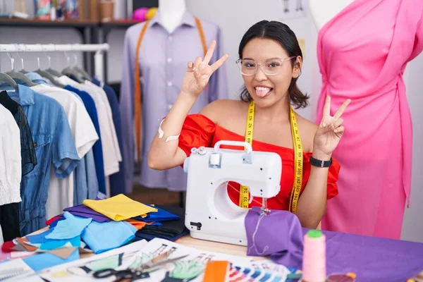 Hispanic Young Woman Dressmaker Designer Using Sewing Machine Smiling Tongue — Stockfoto