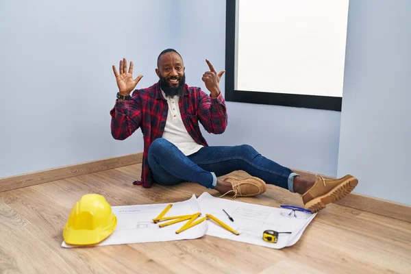 African American Man Sitting Floor New Home Looking Blueprints Showing — Stock Photo, Image