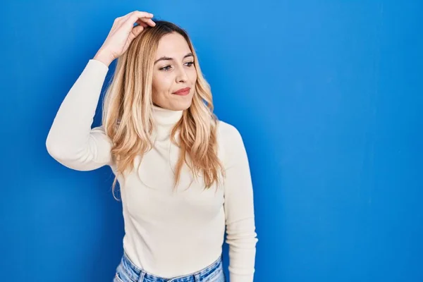 Young Caucasian Woman Standing Blue Background Smiling Confident Touching Hair — Foto Stock