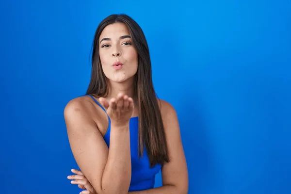 Mulher Hispânica Sobre Fundo Azul Olhando Para Câmera Soprando Beijo — Fotografia de Stock