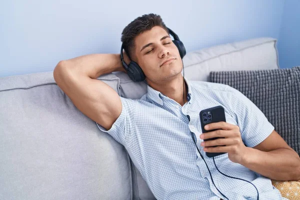 Młody Latynos Słuchający Muzyki Zrelaksowany Kanapie Domu — Zdjęcie stockowe