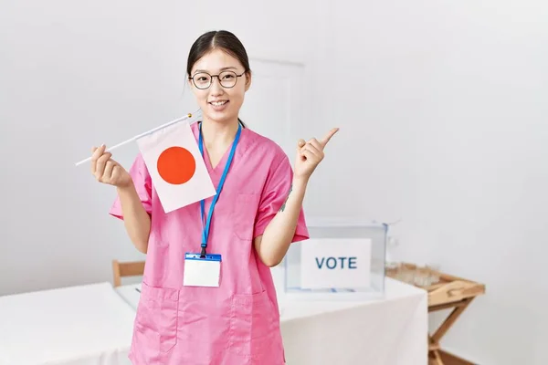 Молодая Женщина Медсестра Азии Выборах Парламент Держит Японский Флаг Улыбаясь — стоковое фото