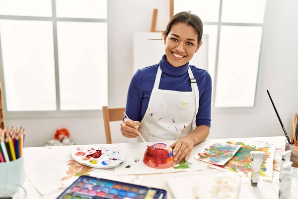 在艺术工作室里 年轻的拉丁女子笑着自信地画粘土陶瓷 — 图库照片