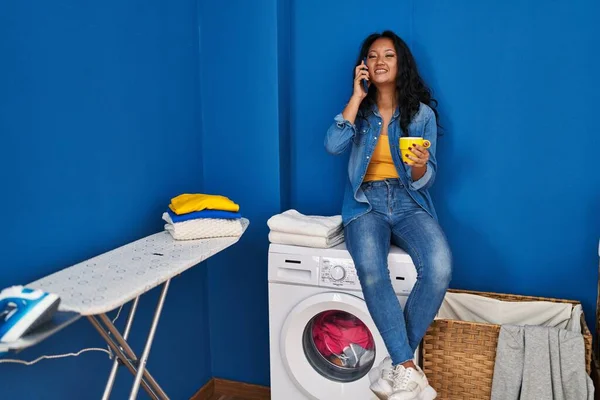 Young Chinese Woman Talking Smartphone Drinking Coffee Waiting Washing Machine — Stock Photo, Image