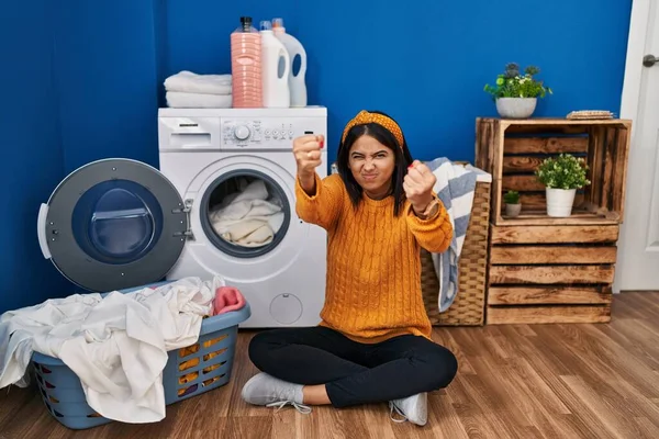 怒って洗濯をしている若いヒスパニック系の女性と怒りで叫んでいる間に怒りと怒りの拳を上げる怒っている 怒りと攻撃的な考え方 — ストック写真