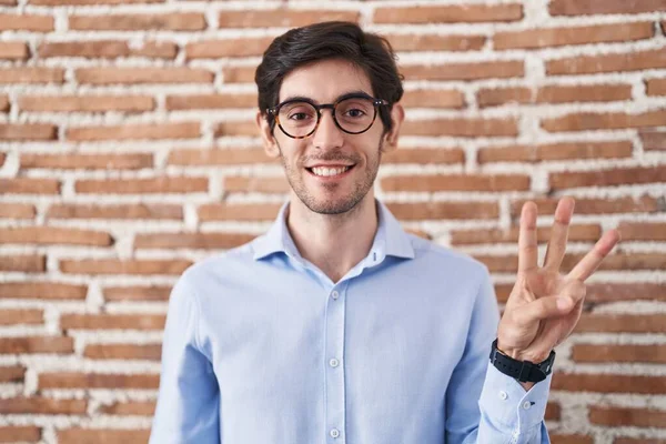 Mladý Hispánec Stojí Nad Cihlovou Zdí Pozadí Ukazuje Ukazuje Prsty — Stock fotografie