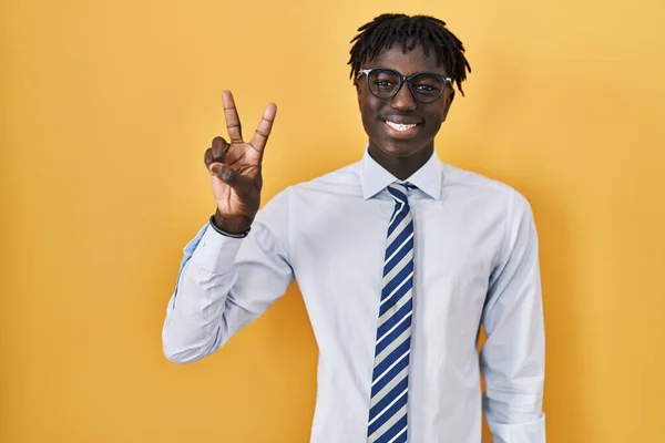在黄色的背景上站着一个害怕的非洲男人 他带着自信和快乐的微笑 用手指着二号 — 图库照片