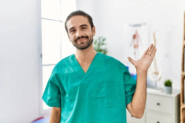 Young Physiotherapist Working Pain Recovery Clinic Smiling Cheerful Presenting Pointing — Stok fotoğraf