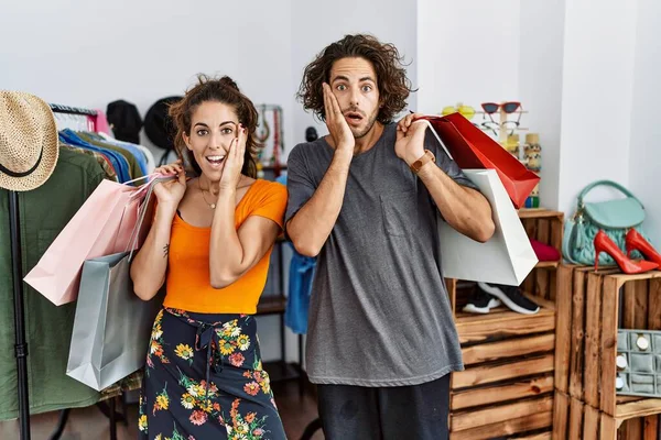 Junges Hispanisches Paar Mit Einkaufstüten Einzelhandelsgeschäft Verängstigt Und Schockiert Überrascht — Stockfoto