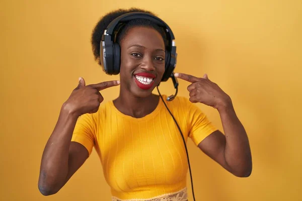 African Woman Curly Hair Standing Yellow Background Wearing Headphones Smiling — Stock Photo, Image