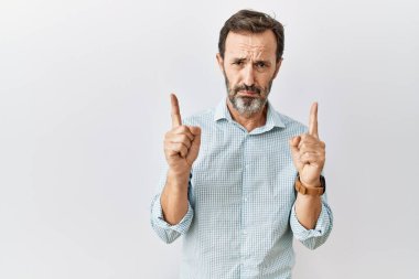 Arka planda sakallı, orta yaşlı İspanyol bir adam üzgün ve üzgün görünüyor, parmaklarıyla yönü gösteriyor, mutsuz ve depresif.. 