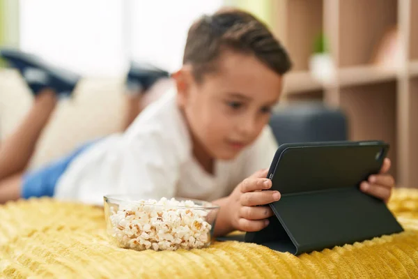 Adorável Criança Hispânica Assistindo Vídeo Touchpad Deitado Sofá Casa — Fotografia de Stock