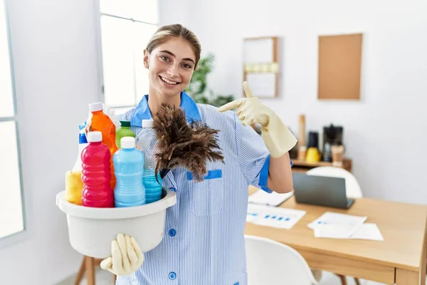 Mujer Rubia Joven Usando Uniforme Más Limpio Sosteniendo Productos Limpieza —  Fotos de Stock