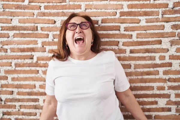 Senior Woman Glasses Standing Bricks Wall Angry Mad Screaming Frustrated — Fotografia de Stock