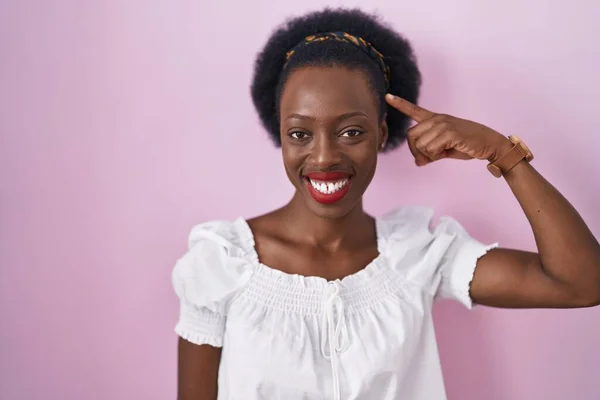 Pembe Arka Planda Duran Kıvırcık Saçlı Afrikalı Kadın Tek Parmakla — Stok fotoğraf
