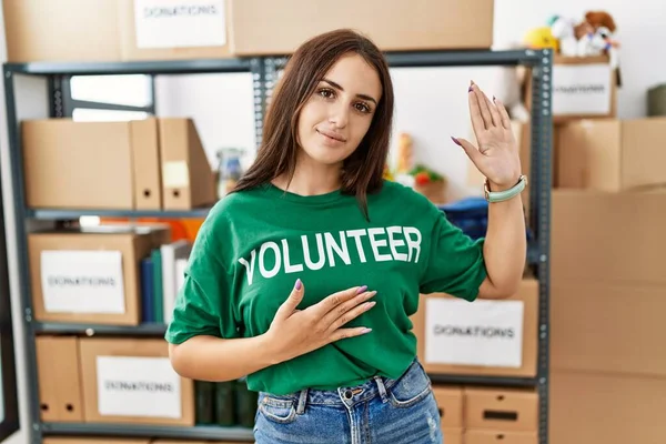 Young Brunette Woman Wearing Volunteer Shirt Donations Stand Swearing Hand — Stock Photo, Image