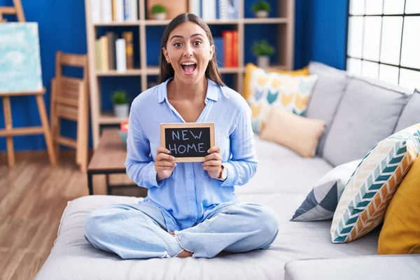 Young Hispanic Woman Holding Blackboard New Home Text Sitting Sofa — Stockfoto