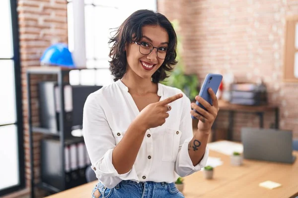 Молода Іспаномовна Жінка Працює Офісі Використовуючи Смартфон Усміхнений Щасливий Вказуючи — стокове фото