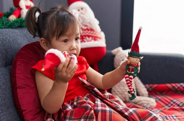 Adorable Chica China Sosteniendo Juguetes Navidad Sentado Sofá Casa — Foto de Stock
