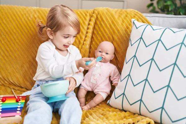 Evdeki Kanepede Oturan Sevimli Beyaz Kız Oyuncak Bebekle Oynuyor — Stok fotoğraf