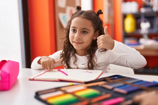 Adorable Hispanic Girl Student Sitting Table Drawing Notebook Classroom — Fotografia de Stock